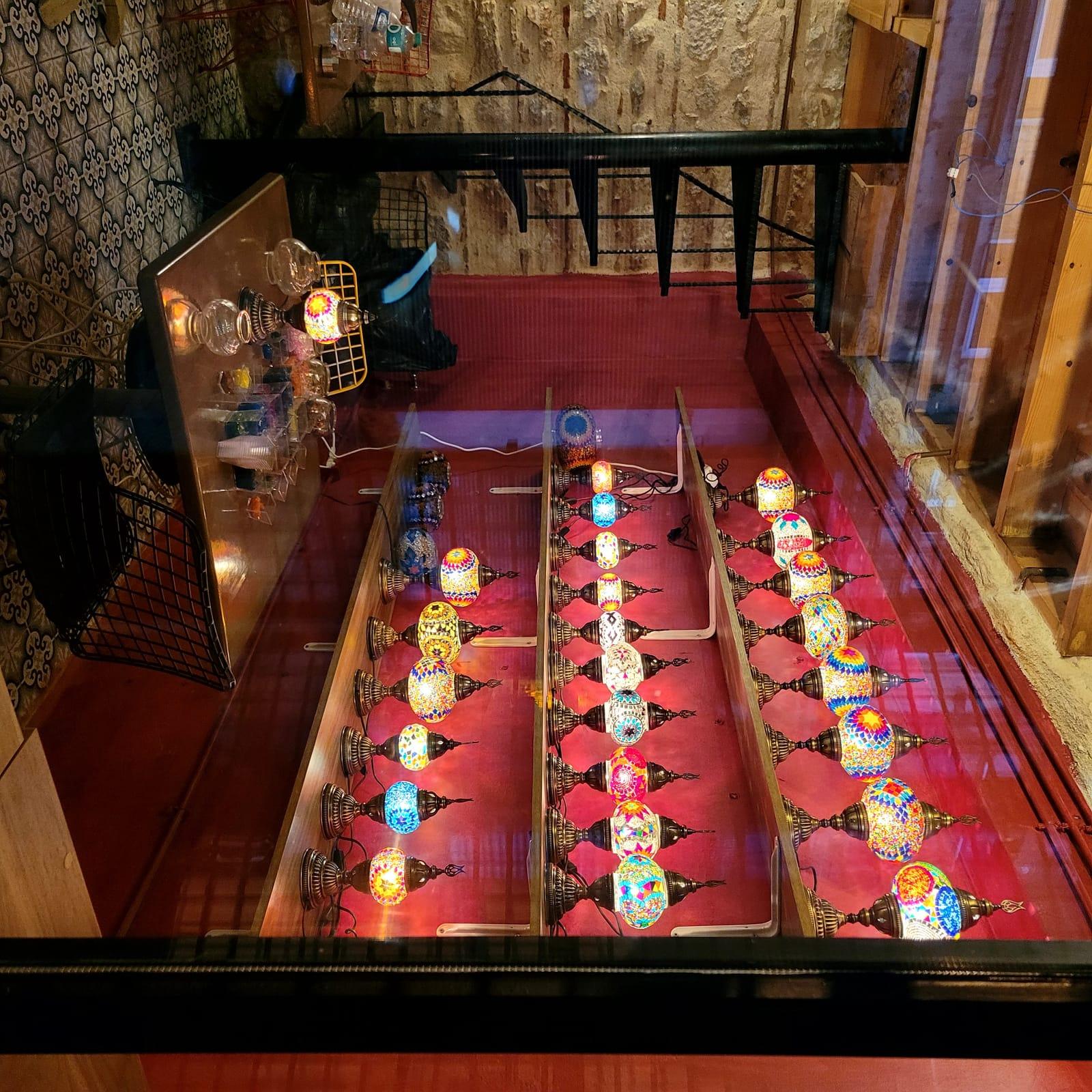 Interior of Glow Balat studio in Balat, Istanbul — stone walls and a full wall of glowing mosaic lamps